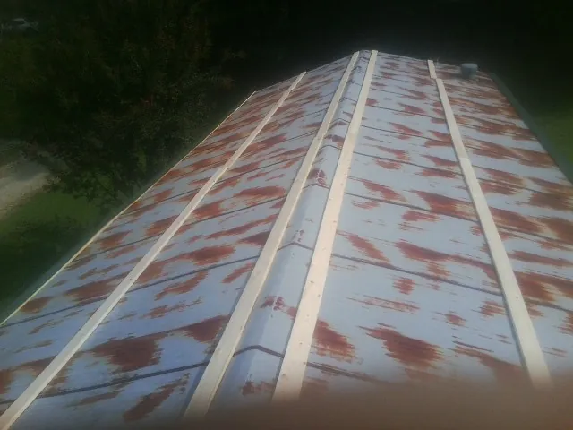 Rusted metal roof panels with new wood purlins before replacement — Storm Damage Roof Repair in Sterrett by Roofing Brothers