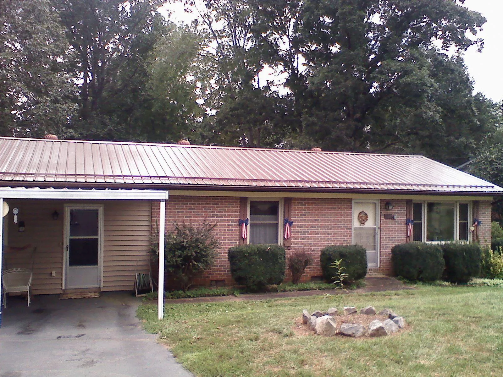 Bronze metal roof and carport on a brick ranch home — Roof Repair work by our crew in Sterrett